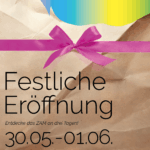 Ein angerissenes Packpapier mit rosa SChleife, dahinter kommen die ZAM Farben heraus. Das ZAM ist ein Geschenk.